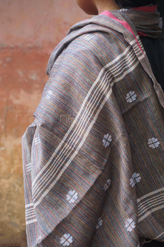 Person wearing a patterned shawl with a neutral background
