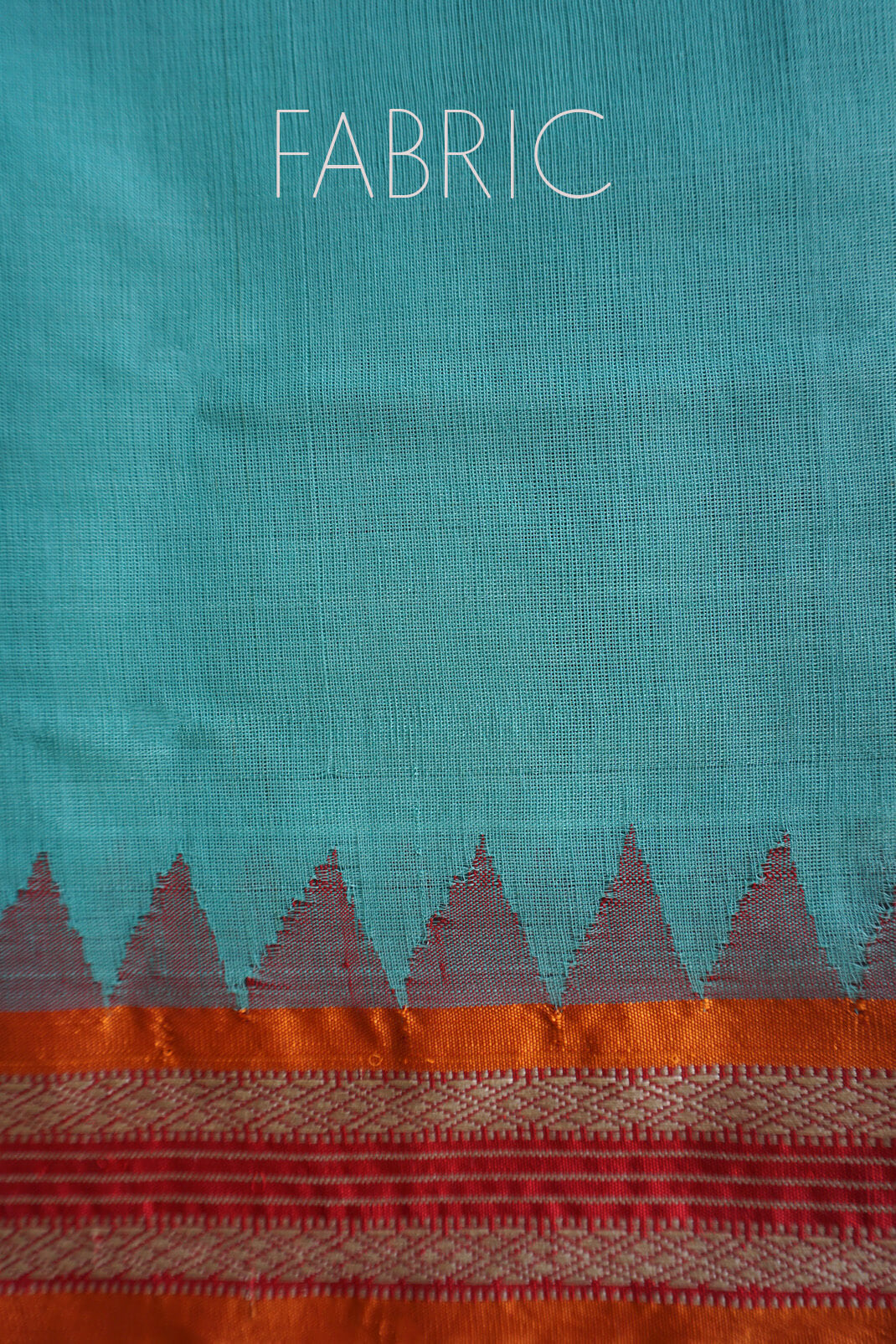 A close-up of a teal blue fabric with a decorative border at the bottom, featuring a row of gray triangles above an orange and red patterned band. The word 'FABRIC' is printed in white at the top.