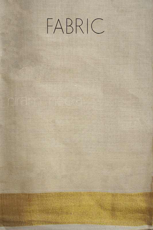 Cream fabric with a gold border on a textured dark surface | Niram Neela