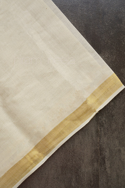 Cream fabric with a gold border on a textured dark surface | Niram Neela
