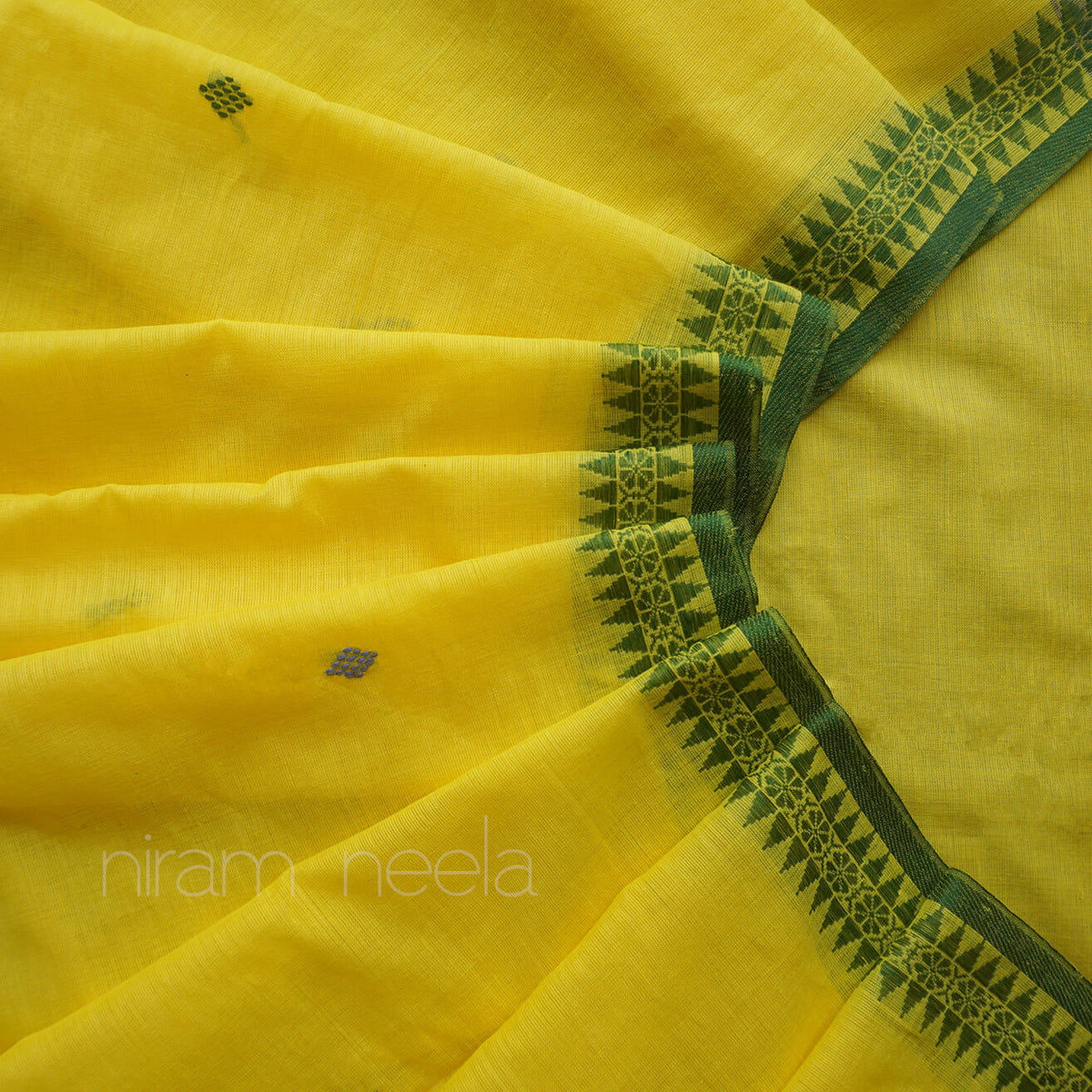 Yellow saree with a dark green geometric border pattern and small woven motifs, shown in a close-up draped layout with a visible 'niram neela' watermark.