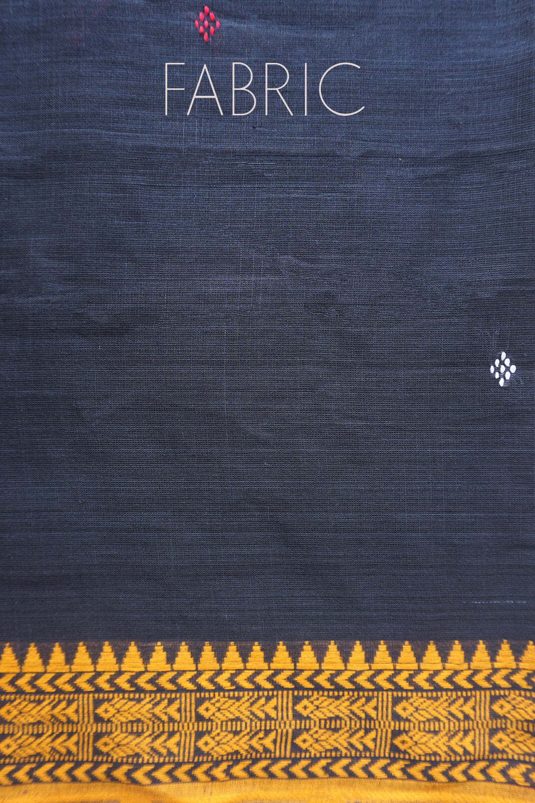 A close-up of dark gray fabric with a decorative border at the bottom in yellow geometric patterns. The word 'FABRIC' is printed near the top.