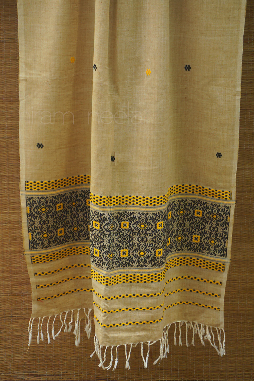 Beige scarf with black and yellow patterns on a brown background