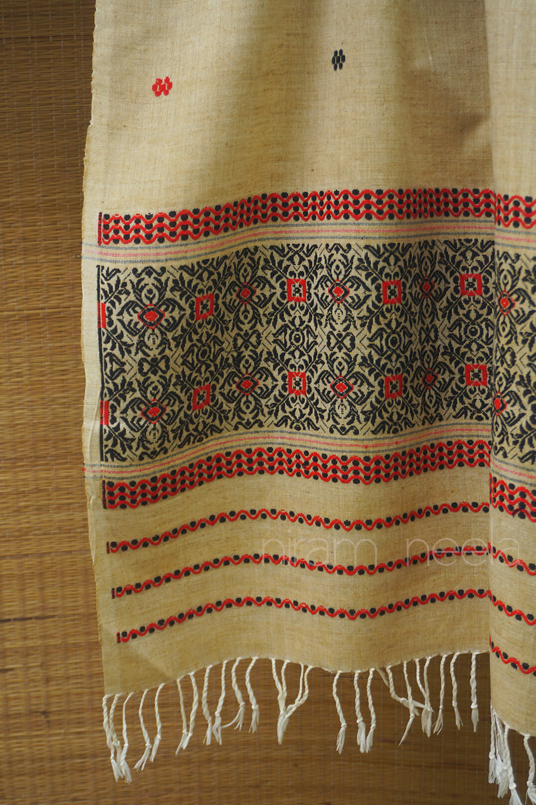  Cream Scarf with intricate patterns and red accents on a wooden surface