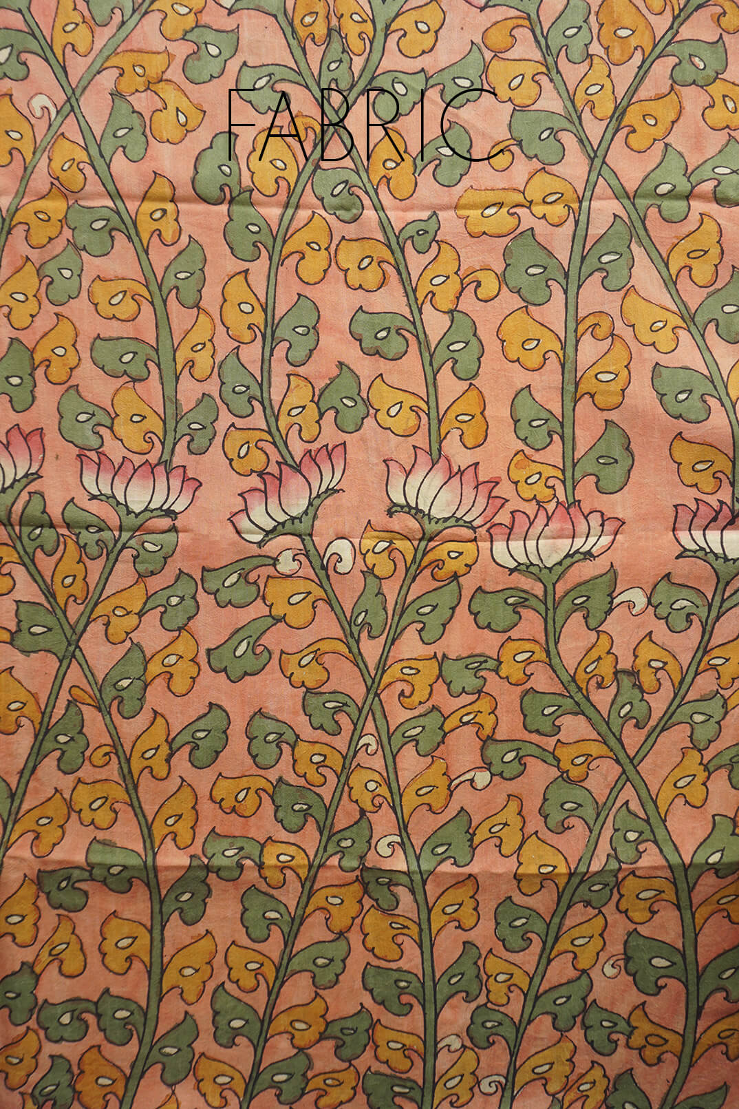 A close-up of patterned fabric with a peach background, repeating green and mustard yellow leafy stems and pink-and-white flower motifs. The word FABRIC is printed across the top as an overlay.