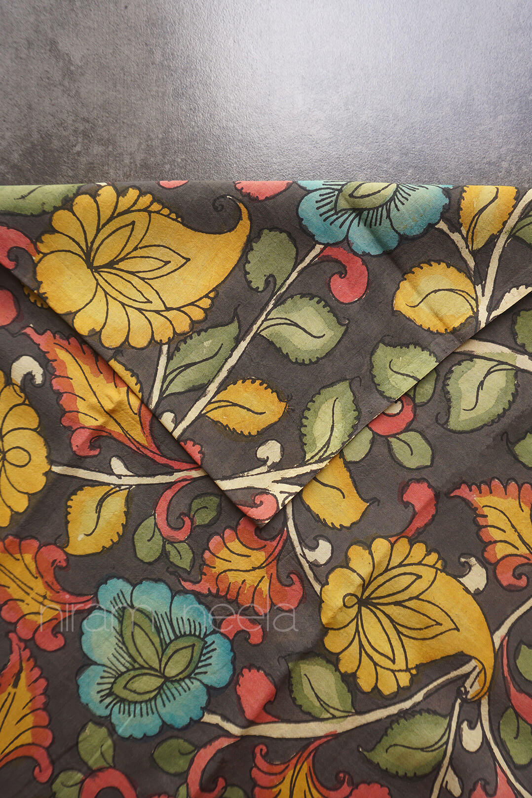 Dark grey fabric with all over floral design in ochre yellow and blue against a grey background