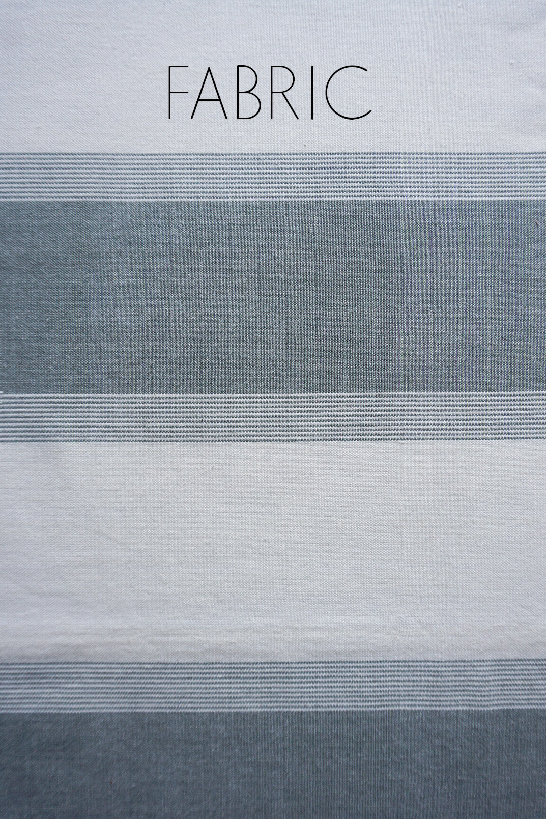 A close-up of striped fabric with the word FABRIC printed at the top, showing alternating white and muted gray horizontal bands.
