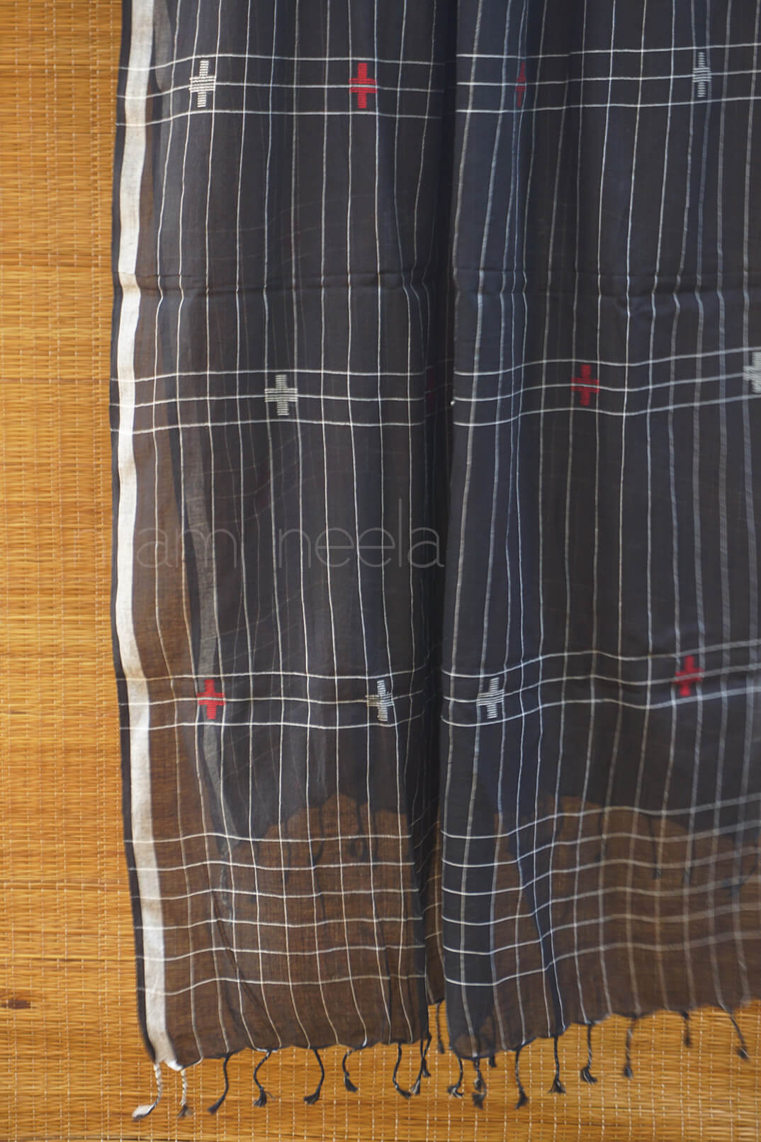 Black and white checkered scarf with red accents on a wooden surface