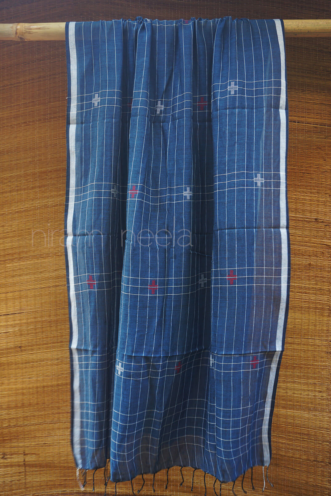 Blue checkered fabric with red accents on a wooden background