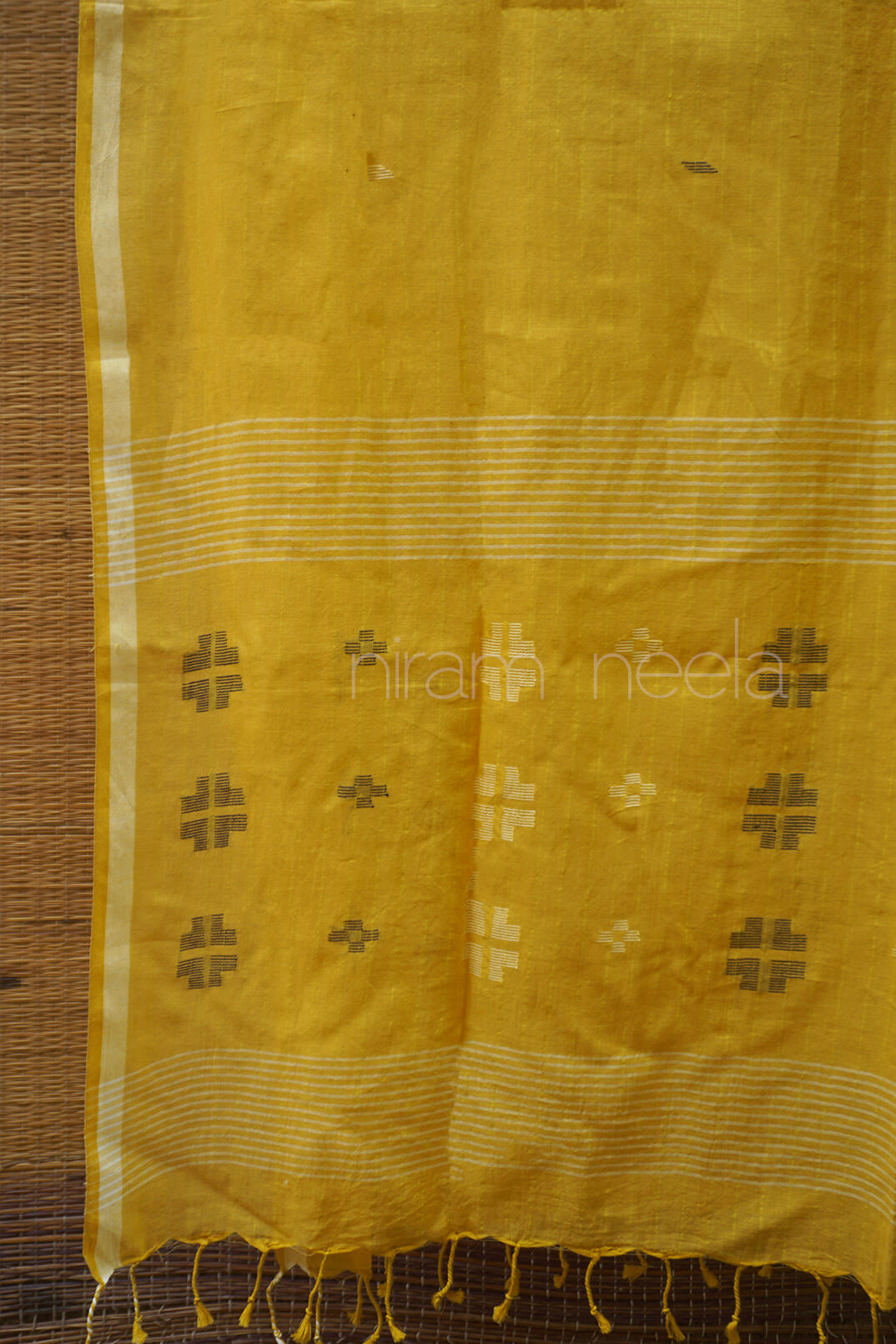 Yellow fabric with intricate patterns and 'niram neela' branding.