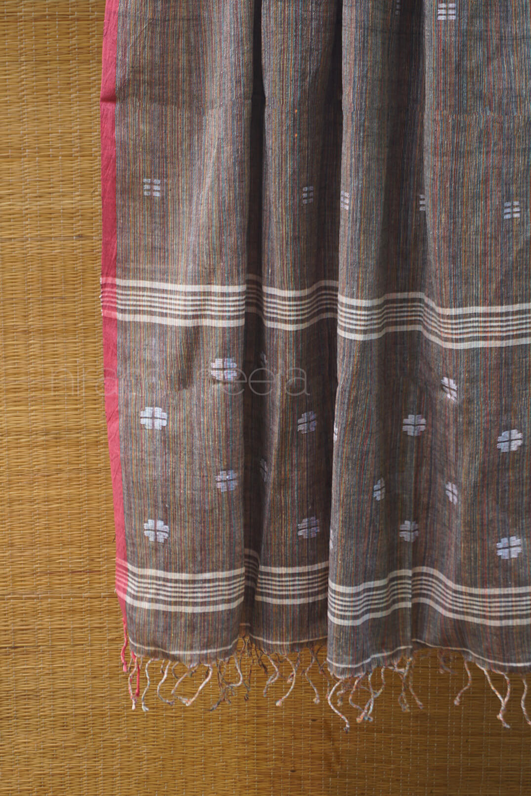 Brown fabric with white patterns and fringes on a brown background