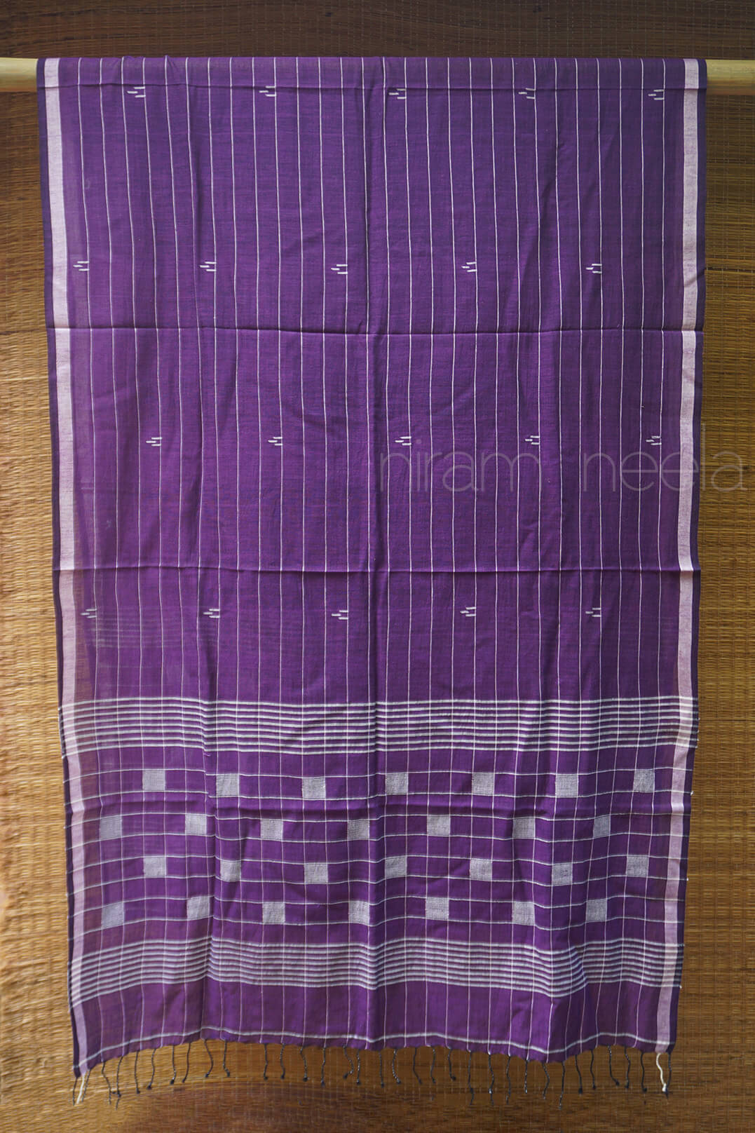 Purple fabric with white patterns on a wooden surface