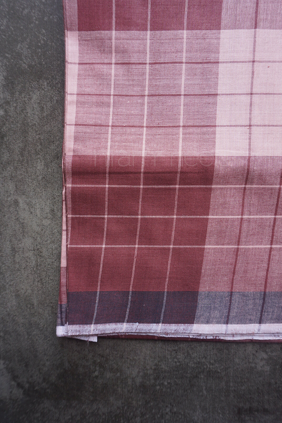 Plaid fabric with red and white pattern on a dark background