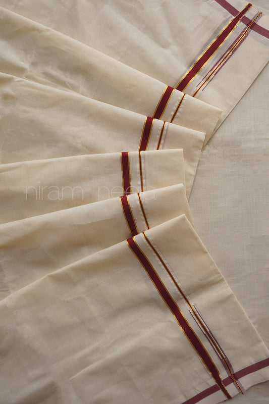 An off-white cotton fabric, likely a saree, featuring narrow maroon and gold border stripes along the edges, laid out in soft folds.